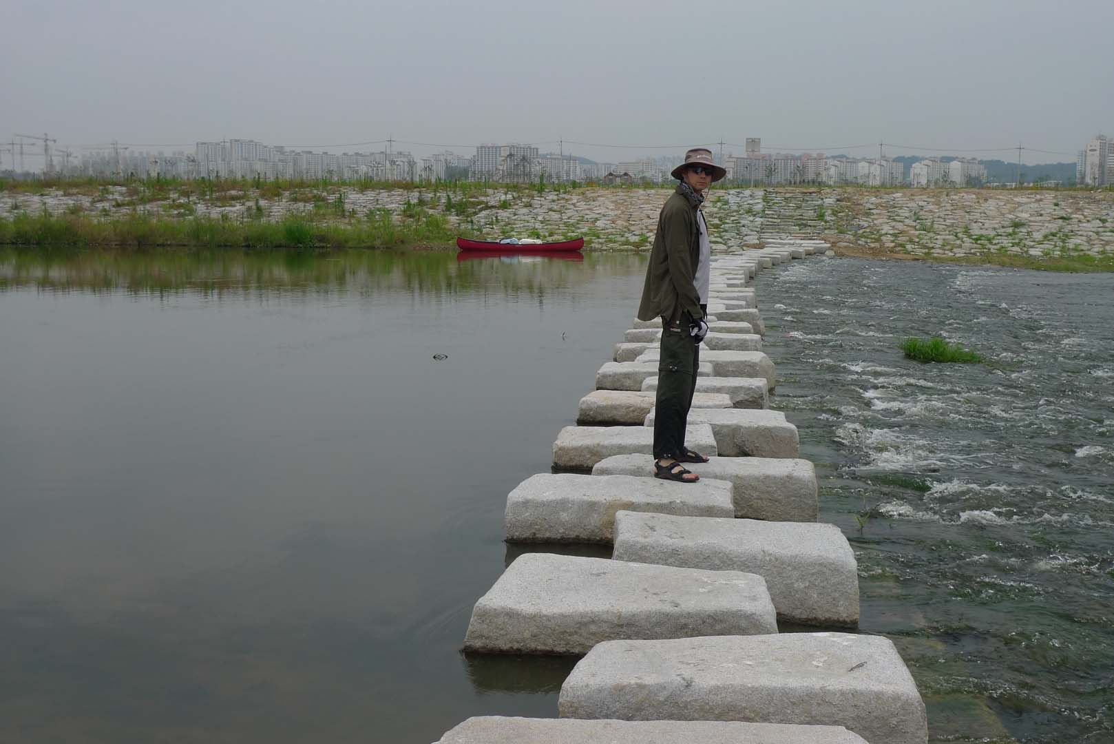 person standing on stone bridge used to walk across river