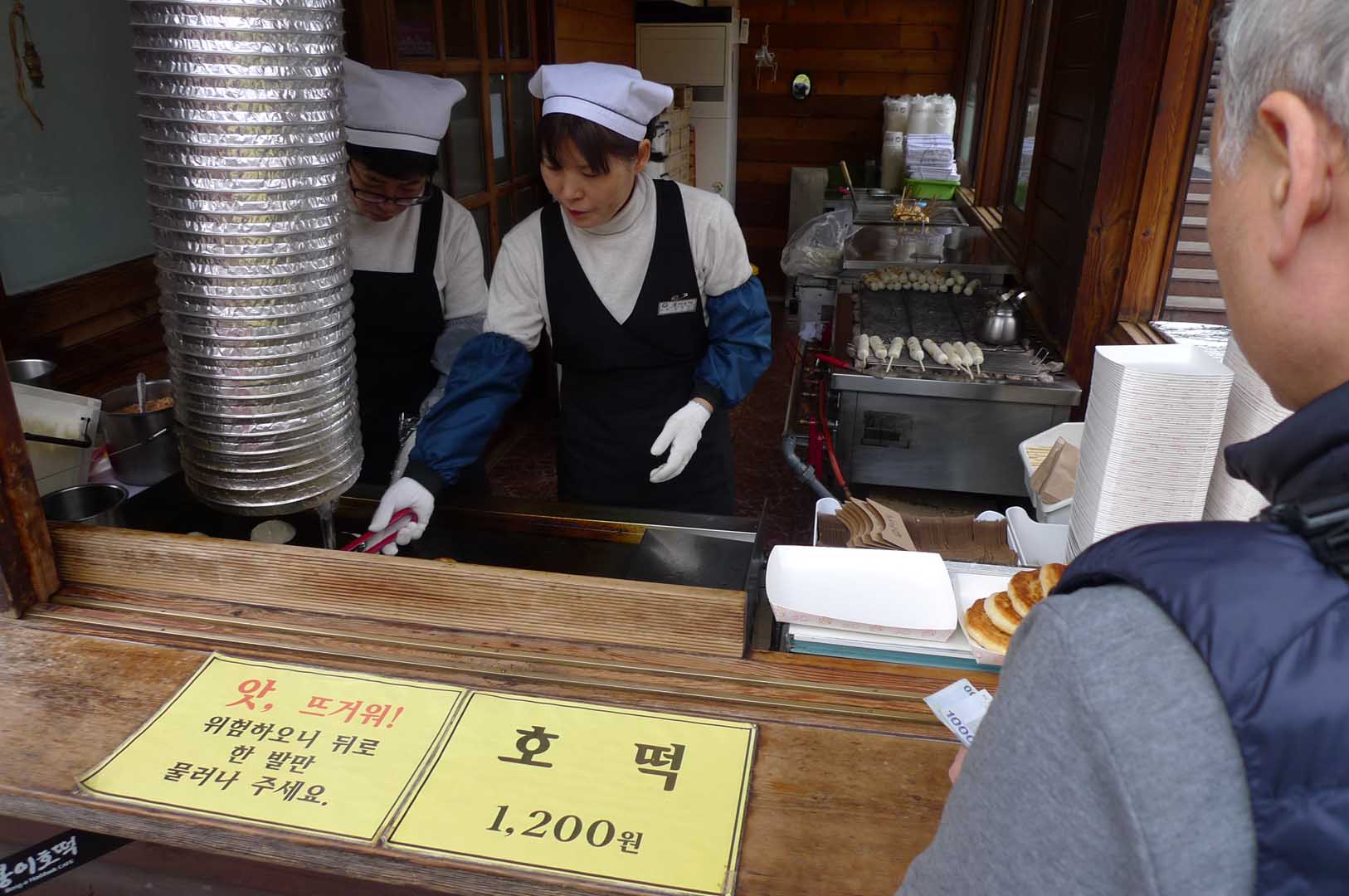 i picture of a korean food cook at a food selling booth